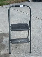 Full view of gray steel two-step folding ladder