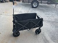 Side view of black folding wagon with handle extended