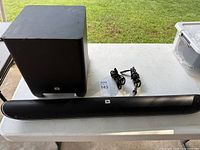 Soundbar, subwoofer and power cords on table