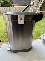 Full view of stainless steel trash can showing pedal, lid and body