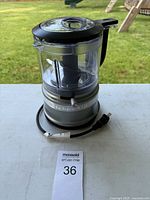 Overall view of silver KitchenAid mini food processor with lid and cord