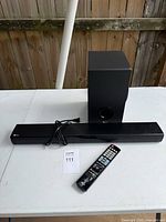Soundbar, subwoofer, remote laid out on table