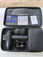 Massage gun, charger, mesh pouch and manual in carrying case
