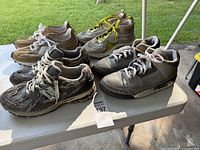 All four pairs of size 12 sneakers displayed on table