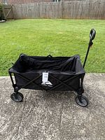 Full view of unfolded black folding wagon with handle extended