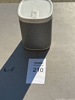 Front view of Sonos One speaker with lot tag