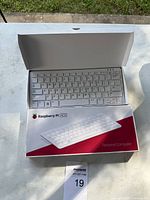 Open box showing white Raspberry Pi 400 keyboard inside packaging