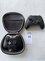 Both controllers, Elite in case, lot identifier visible