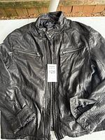 Front view of black leather jacket with zippers visible