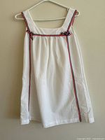 Sleeveless white pinafore dress with trim