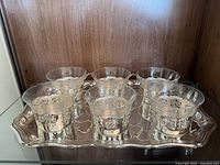 Six cups with holders arranged on tray inside cabinet