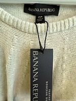 Close-up of Banana Republic label and hang tag on light heather sweater