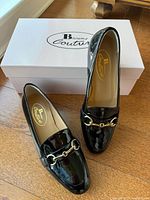 Pair of loafers on box showing uppers, brand logo visible