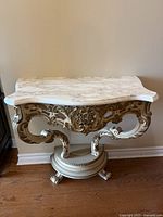 Front view of entire demilune console showing marble top and carved base