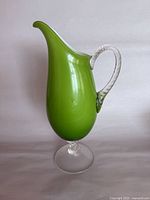 Full view of lime green art glass pitcher on clear pedestal foot