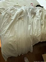Five white vintage nightgowns laid out showing overall styles and lace detailing