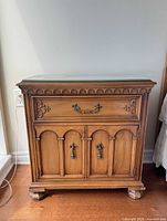 Front view of nightstand showing drawer, cabinet, hardware, glass top