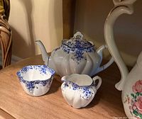 Teapot, sugar bowl, and creamer grouped together showing overall form and pattern