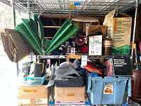 Chrome rack loaded with tarps, boxed stove, lantern, heater, flashlights and bins