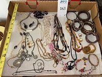 Tray containing assorted necklaces, bracelets, earrings and loose charms