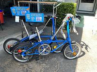 Two blue Dahon folding bicycles and two boxed RadEasy bike hoists