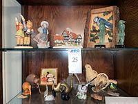 All items displayed on two glass shelves including porcelain, jade, brass, wood and ceramic figurines