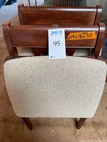 Front view of one chair showing upholstered seat and slatted back