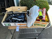 Full lot on metal cart: skates box, banana box with ball & shuttlecock cans, pole, shopping bag with cloths