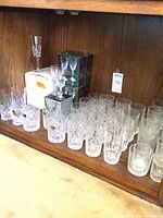 Cabinet shelf with multiple crystal glasses and original boxes
