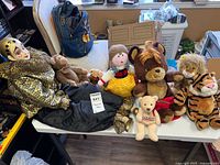 all items on table: clown doll, plush toys