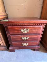 Front view nightstand showing three drawers and hardware