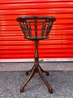 Full view of wood pedestal plant stand against red door