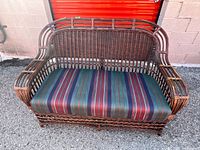 Front view of wicker loveseat with striped cushion