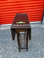 Table folded, side profile showing slim gate-leg structure