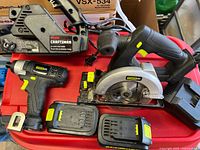 Overview showing Craftsman belt sander, Power It circular saw, drill and batteries