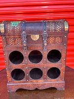 Front view showing six bottle openings, domed lid, metal accents