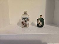 Both perfume bottles side by side on shelf showing design details and relative size