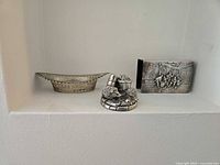 Pierced dish, animal figurine, matchbox cover on shelf