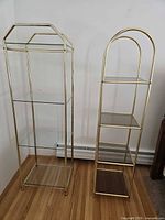 Front view of both brass framed glass display cases showing shelf types and overall condition