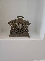 Front view of brass letter holder showing floral openwork design and overall form