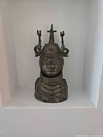 Front view of brass Benin style head showing full headdress and collar