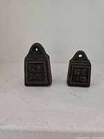 Front view of both iron seals showing size difference, Chinese characters, and weight markings