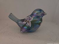 Side view of iridescent blue/teal Fenton glass bird figurine showing hand-painted floral motif