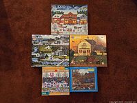 Five Charles Wysocki 1000-piece puzzle boxes laid out on carpet