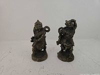 Front view of both metal alloy guardian warrior figurines standing on bases