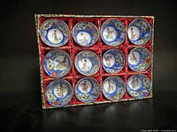 Front view of all 12 cups seated in red-lined display box