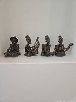 All four bronze-tone jazz musician figurines with instruments displayed together