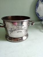 Front view of silver-plated trophy cup showing inscription and handles