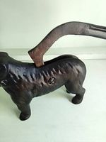 Side view of cast iron dog nutcracker standing, lever tail visible