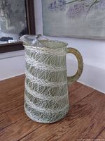 Front view of translucent green spaghetti glass jug